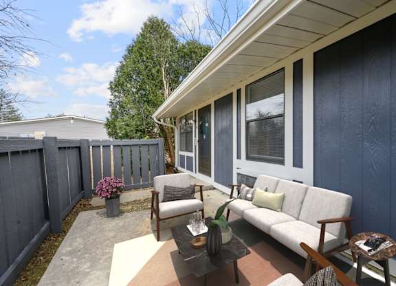 A patio with a couch, chairs, and a coffee table.