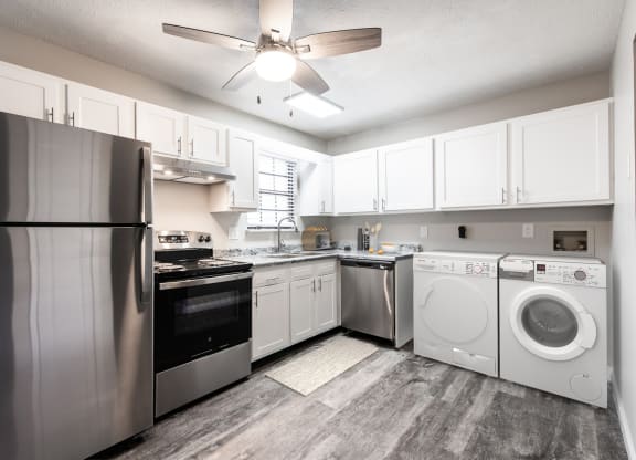 a kitchen with white cabinets and stainless steel appliances