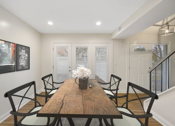 a dining room with a wooden table and black chairs at Harpers Point Apartments, Cincinnati, Ohio