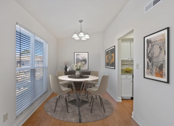 a dining room with a table and chairs and a large window at Harpers Point Apartments, Ohio