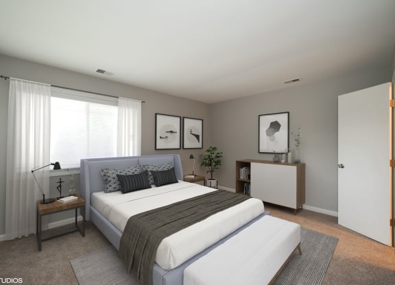 a bedroom with a bed and a dresser  at 7 Pointe Apartments, Indianapolis, IN, 46205