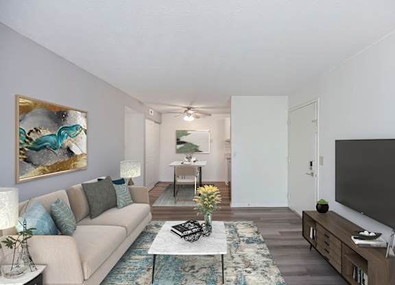 A living room with a couch, a coffee table, and a painting on the wall.
