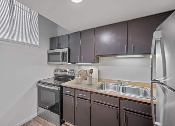 A kitchen with brown cabinets and stainless steel appliances.