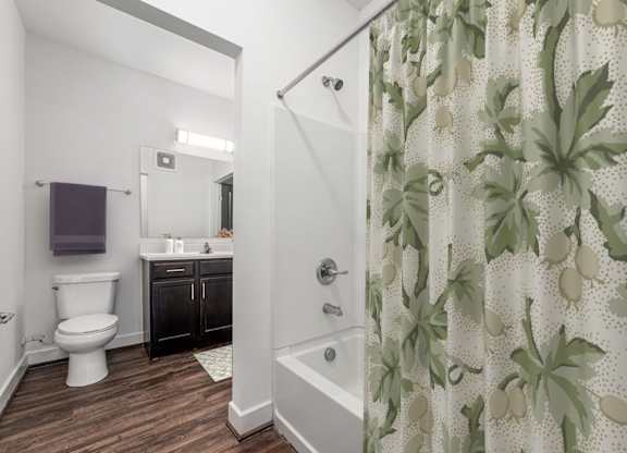 A bathroom with a toilet, sink, and shower curtain. at River View at Bexley Apartments, River View at Bexley, Ohio