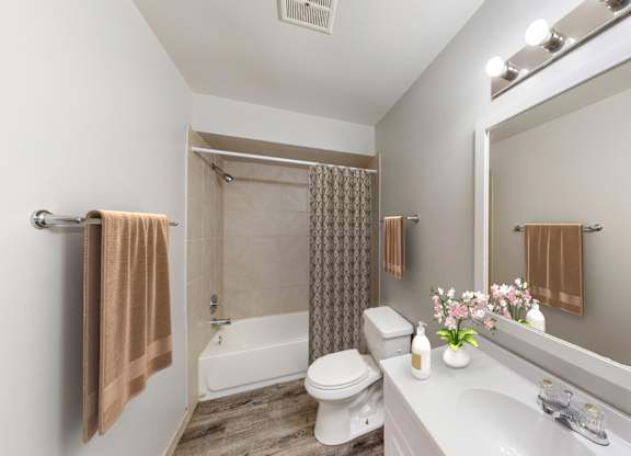 A bathroom with a toilet, sink, and shower.