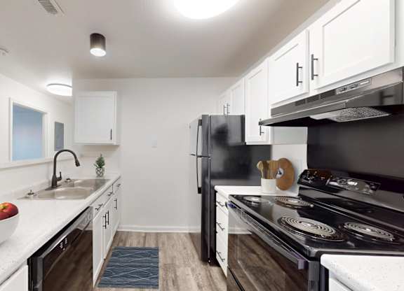 A kitchen with black appliances and white cabinets.
