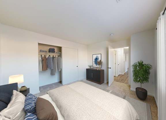A bedroom with a bed, a potted plant, and a wardrobe.