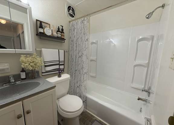 A white bathroom with a toilet, sink, and bathtub.