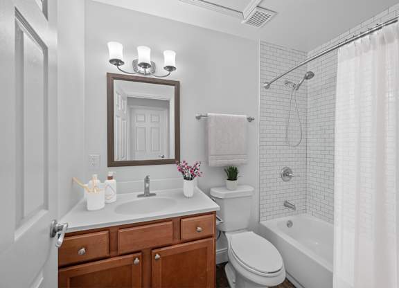 A white bathroom with a toilet, sink, and shower.