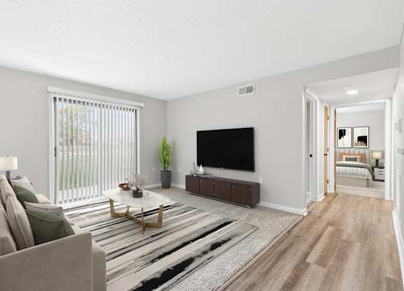 A living room with a couch, a coffee table, and a television.