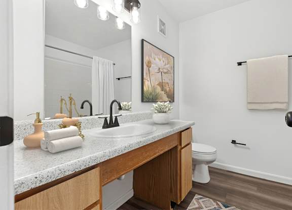 A bathroom with a white countertop and a towel hanging on the wall.