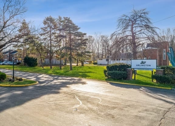a parking lot in front of an elementary school with trees and grass