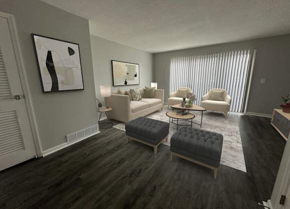 A living room with a grey couch, a black ottoman, and a painting on the wall.