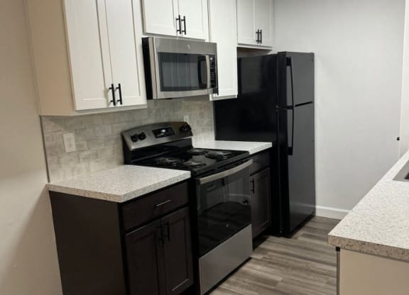 Kitchen with black appliances and white cabinets  at Hilltop Apartments, Ohio