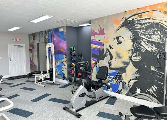 A gym with a woman's face painted on the wall.