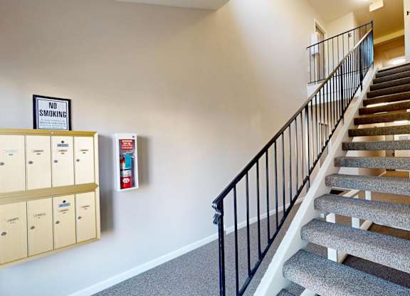 A staircase with a no smoking sign and a fire extinguisher on the wall.