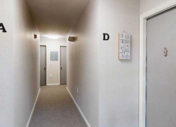 A hallway with doors on the left and right and a poster on the wall.