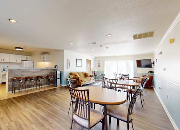 A kitchen with a dining table and chairs.