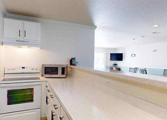 A kitchen with white appliances and a white countertop.