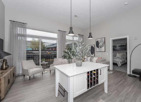 Pet-Friendly Apartments in West Chester, OH - Liberty Center - Living Room with Floor-to-Ceiling Windows, Wood-Style Floors, and Hanging Light Fixtures