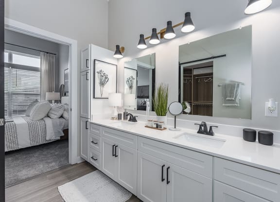 1-Bedroom Apartments in Liberty Township, OH - Liberty Center - Attached Bathroom with Double Vanity Sinks and Mirrors, White Quartz Countertops, and White Cabinets.