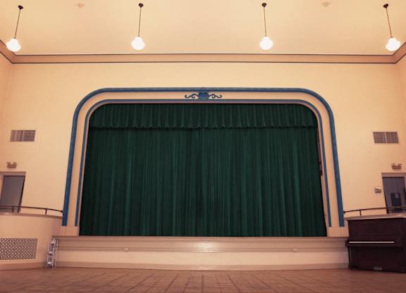 A stage with a green curtain and a blue frame.