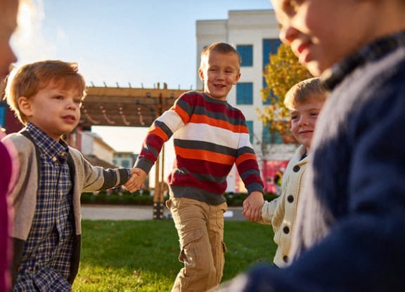 a group of young boys holding hands and laughing
