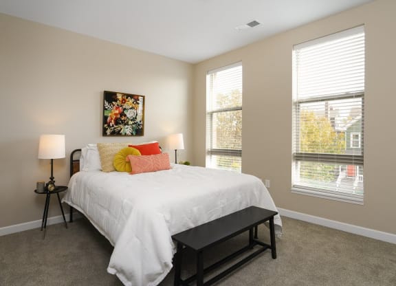 a bedroom with a white bed and two windows at Adelphi Quarter, Columbus