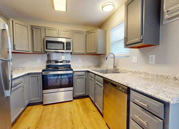 a kitchen with granite counter tops and stainless steel appliances at Ridgeview, Fortville, IN