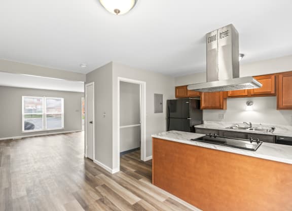 A kitchen with a stainless steel range hood and wooden cabinets.