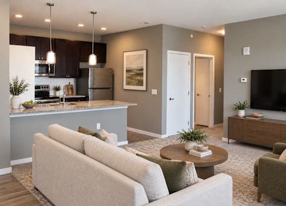 A modern living room with a kitchen area in the background.