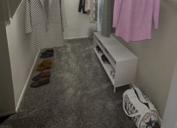 a walk in closet with a white dresser and clothes hanging on the wall