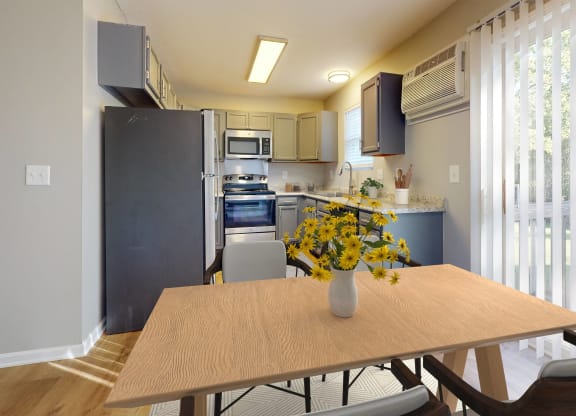 a kitchen with stainless steel appliances and a table with yellow flowers at Ridgeview, Fortville, IN