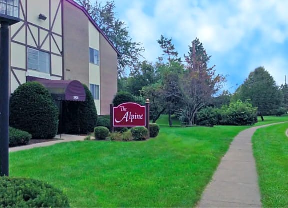 A sign for The Alpine is in front of a building at The Alpine Apartments, Ohio, 45429