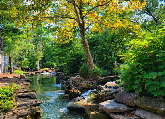 a stream running through a park with rocks and trees at Harpers Point Apartments, Ohio, 45249