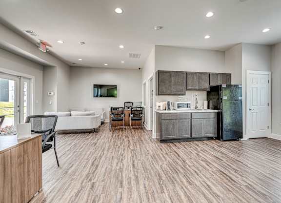 A modern kitchen with a refrigerator, cabinets, and a microwave. at The Apex, Cincinnati