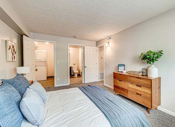 A bedroom with a bed, dresser, and mirror. at The Apex, Cincinnati, 45239