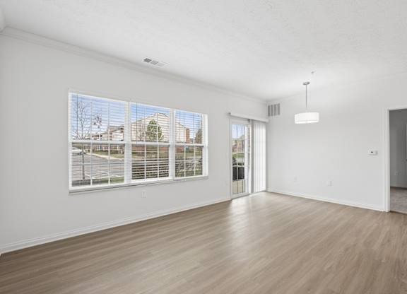 A room with a large window and a sliding glass door.