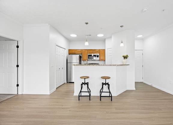A kitchen with a bar stool in front of it.