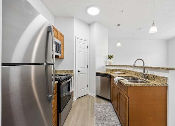 A modern kitchen with a stainless steel refrigerator and wooden cabinets.