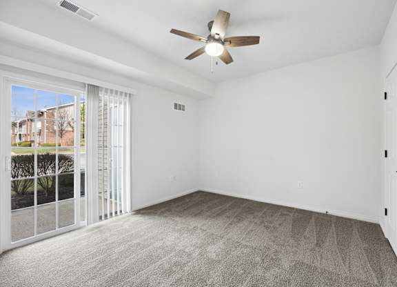A room with a ceiling fan and a carpeted floor.