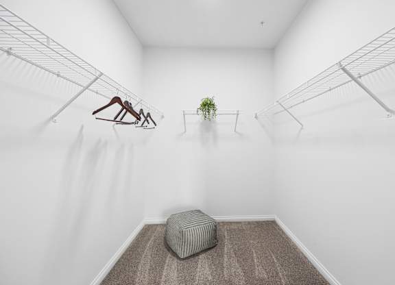 A room with a hanging sculpture, a potted plant, and a bench.