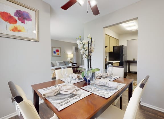 Dining room table with white chairs and a ceiling fan at Summit at Keystone, Indianapolis, 46220