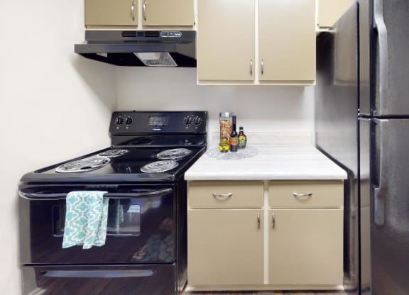 Kitchen with a stove top oven next to a refrigerator at Summit at Keystone, Indianapolis Indiana