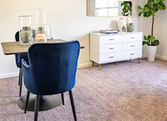 a dining room with a table and chairs and a mirror on the wall