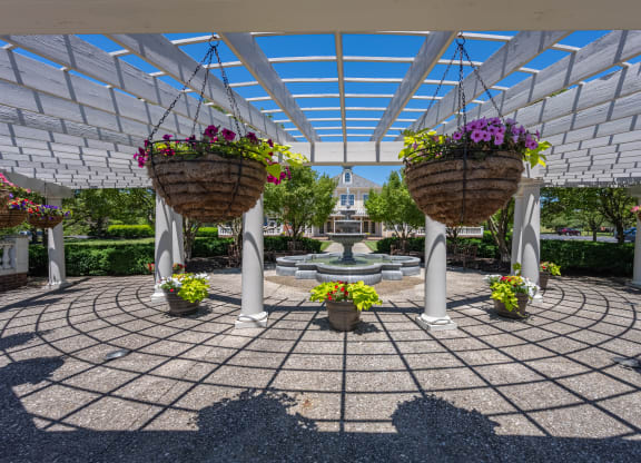 a courtyard with two hanging baskets of flowers and a fountain at Bishops Gate, Cincinnati