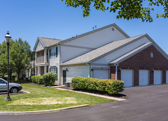 a white house with two garage doors and a lawn at Bishops Gate, Cincinnati, OH, 45249