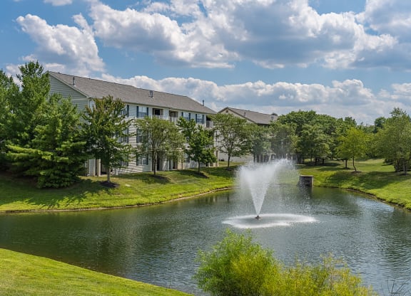 a fountain in the pond with a building in the background at Bishops Gate, Cincinnati