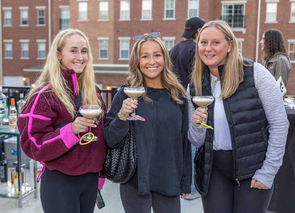 three women holding wine glasses and posing for a picture at Roebling Row, Covington, Kentucky
