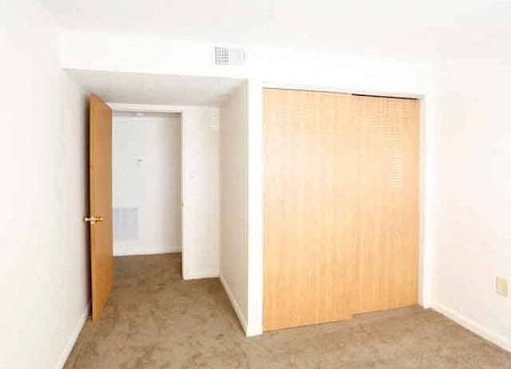 A room with a brown door and a white wall.